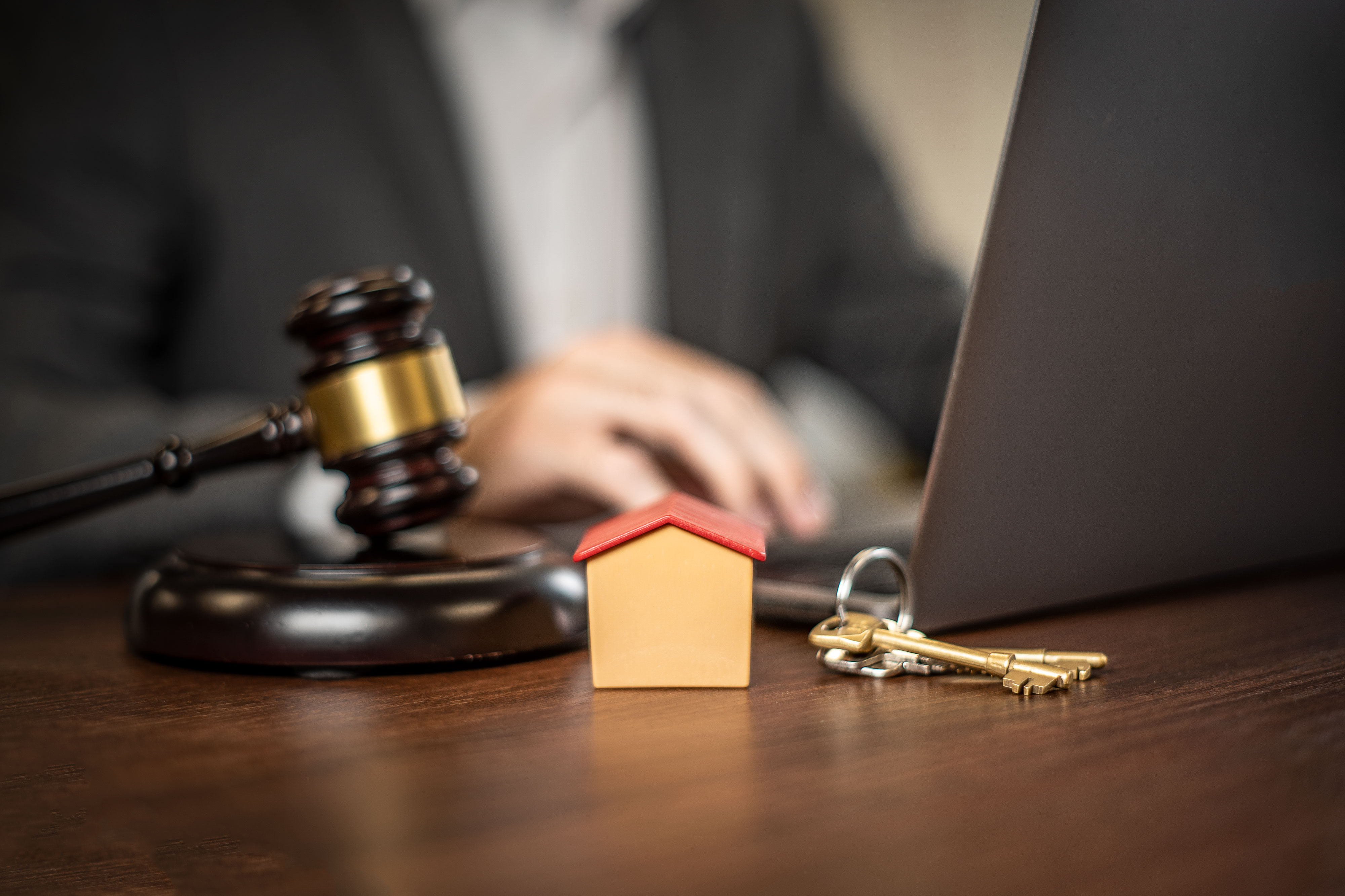 Gavel, model house and keys on a lawyer's desk